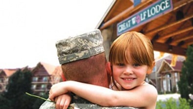 man wearing a blue shirt in front of a Great Wolf lodge